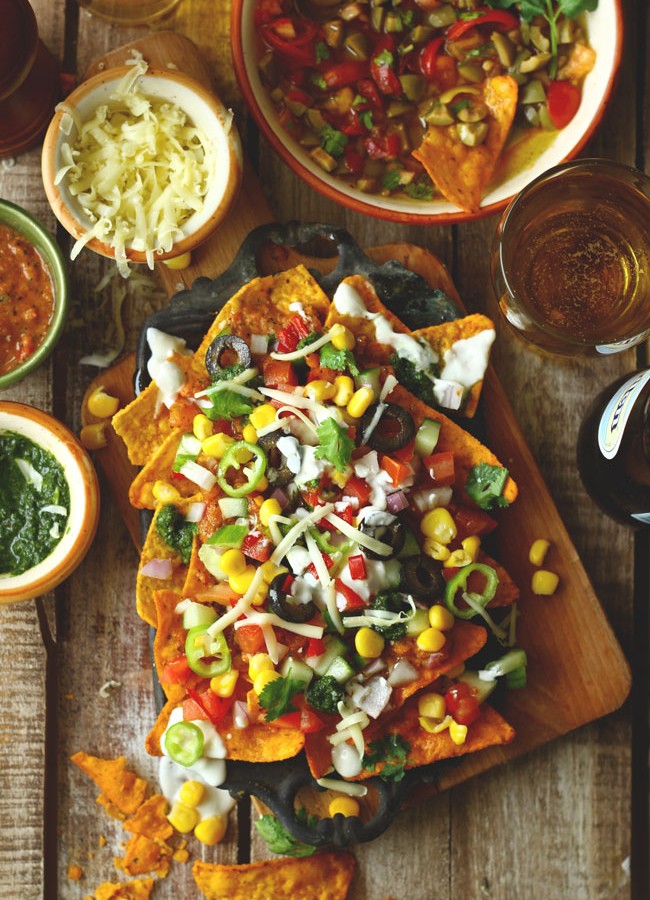 These loaded vegetarian nachos are laced with locally available ingredients and Indian flavors. Find loaded vegetarian nachos recipe