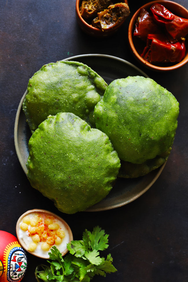 aerial shot of palak puri in a round black plate