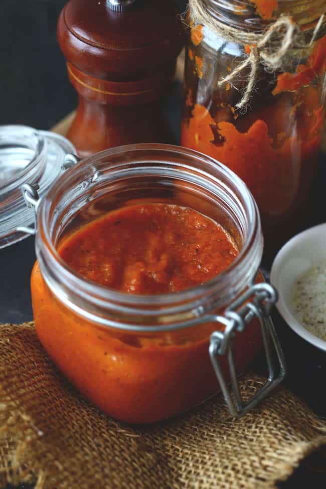 side shot of pizza sauce in a glass bottle