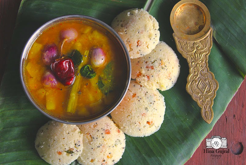 aerial shot of rava idli stacked on a banana leaf.