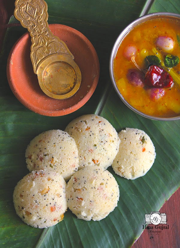 aerial shot of rava idli stacked on a banana leaf.