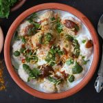 aerial shot of dahi vada served in an earthen pot