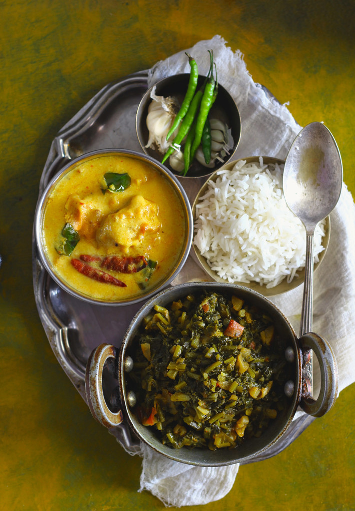 aerial shot of Indian thali meal with Kadhi Pakora, Mooli Ka Saag, Basmati Rice, Green Chili