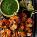 aerial shot of tandoori prawns on a black platter