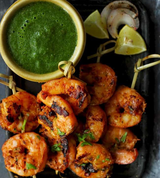 aerial shot of tandoori prawns on a black platter