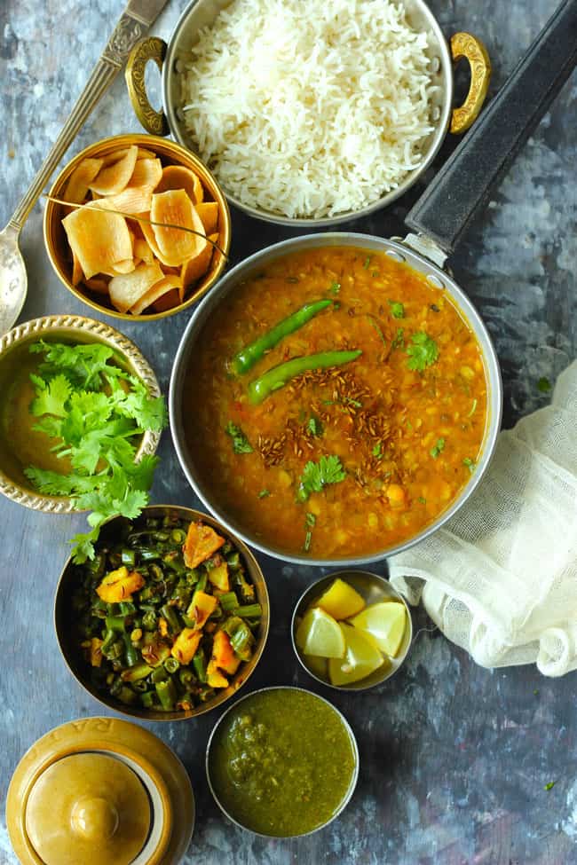 Aerial shot of Indian meal of dal, rice, papad, green beans potato sabzi