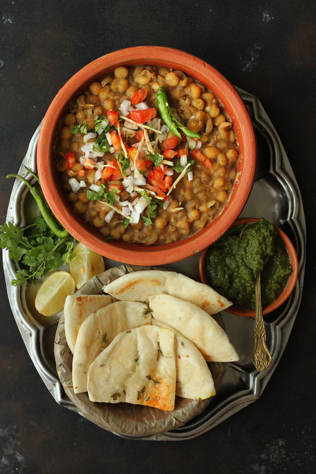 Aerial shot of matar and kulcha in a stainless steel plate.