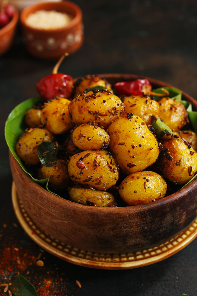 side close up shot of masala potato roast in a wooden bowl