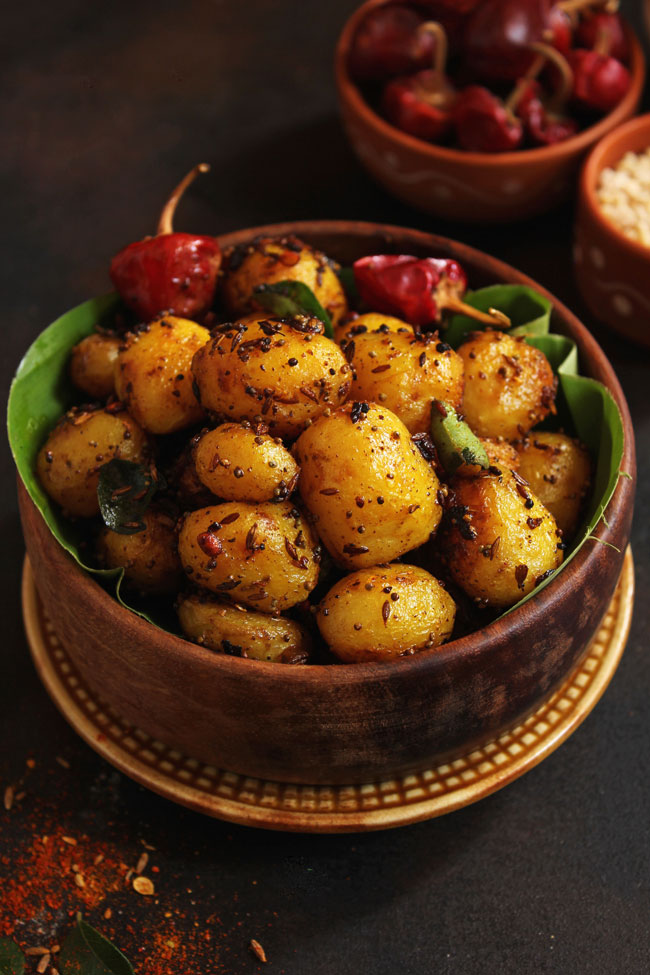 side close up shot of masala potato roast in a wooden bowl