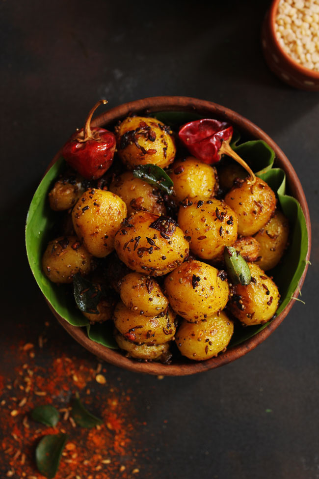 aerial shot of masala potato roast in a wooden bowl