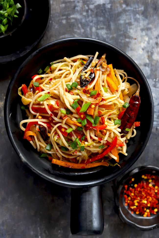 aerial shot of chilli garlic noodles in a black serving bowl