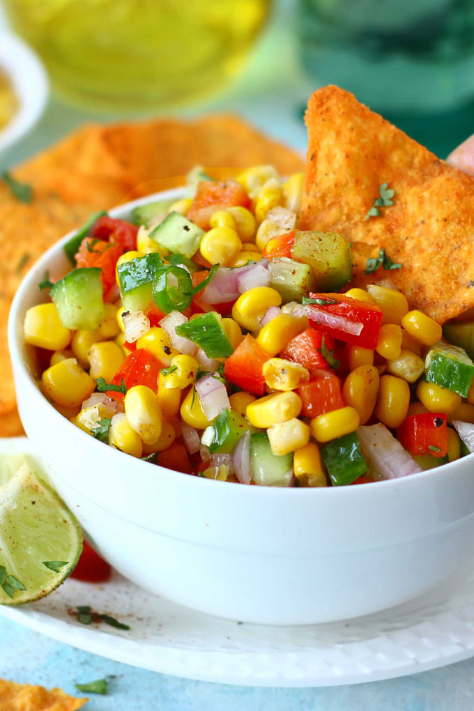 side shot of corn salad in a bowl with nachos