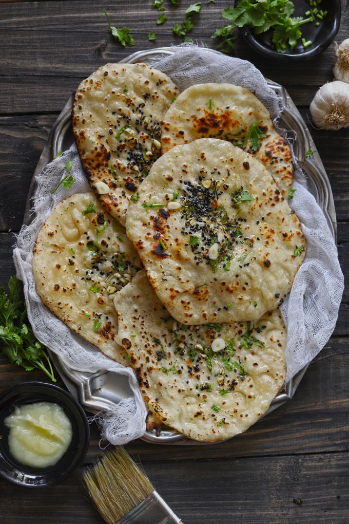 Indian Naan Bread Topped With Chopped Coriander, Mint, Garlic, Nigella Seeds