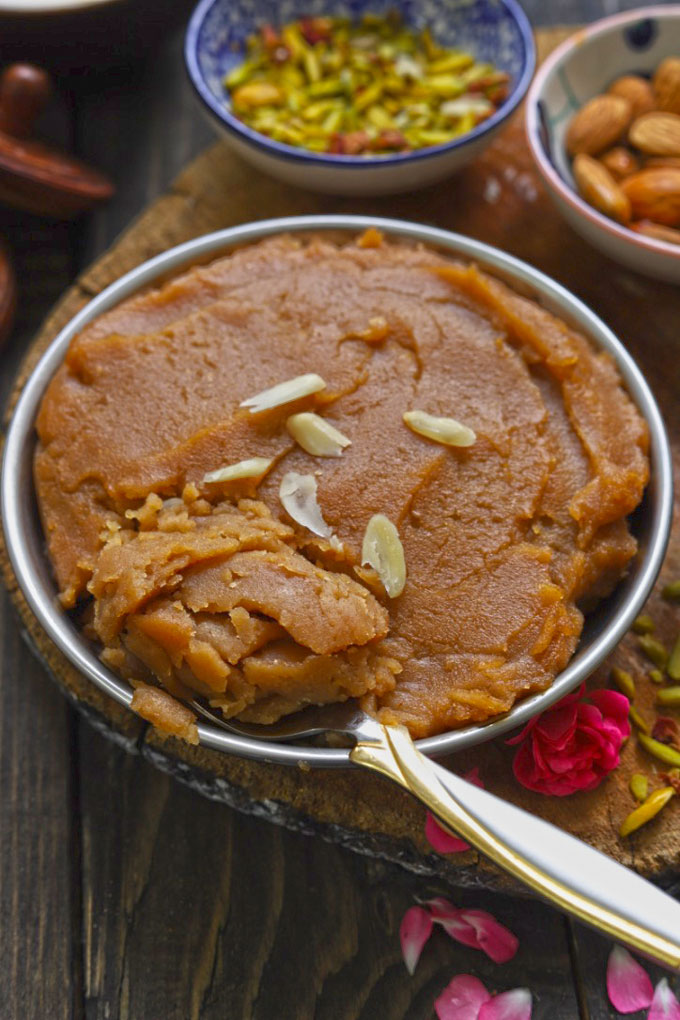 Aate Ka Halwa Garnished With Almonds In A Bowl With Spoon