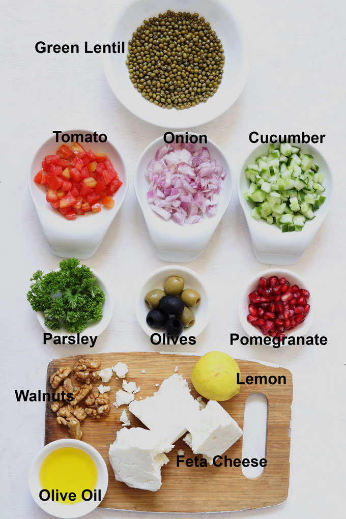 Aerial shot of ingredients arranged in white bowls for making lentil salad on a white background