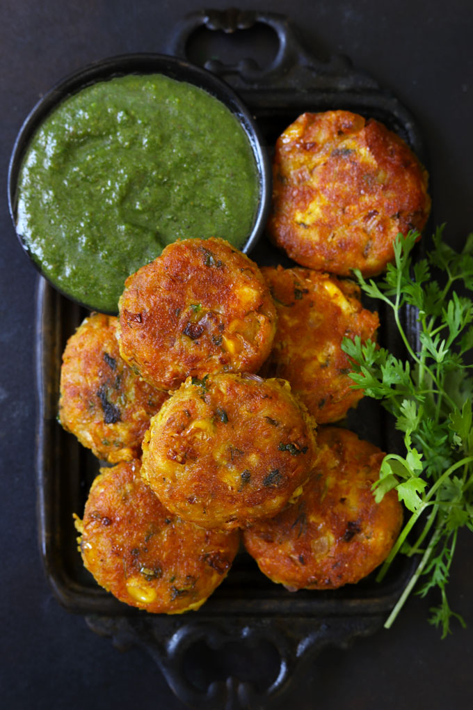 Aerial Shot of Corn Paneer Cutlet in a Black Tray With Green Chutney