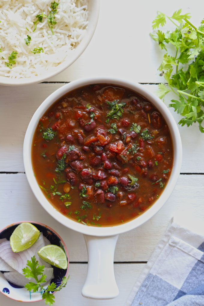 Aerial shot of rajma masala in a white serving bowl on a white background.