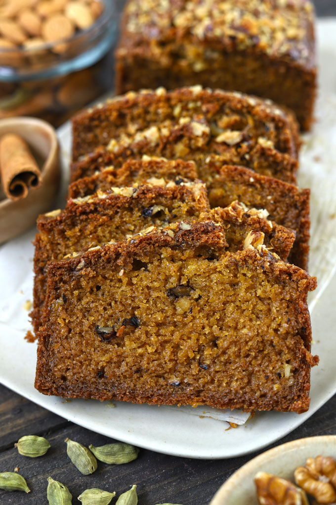 Side shot of eggless whole wheat cake slices in a white platter.