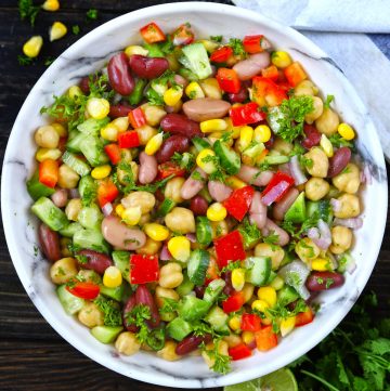 Aerial shot of Mexican style mixed beans salad in a white bowl
