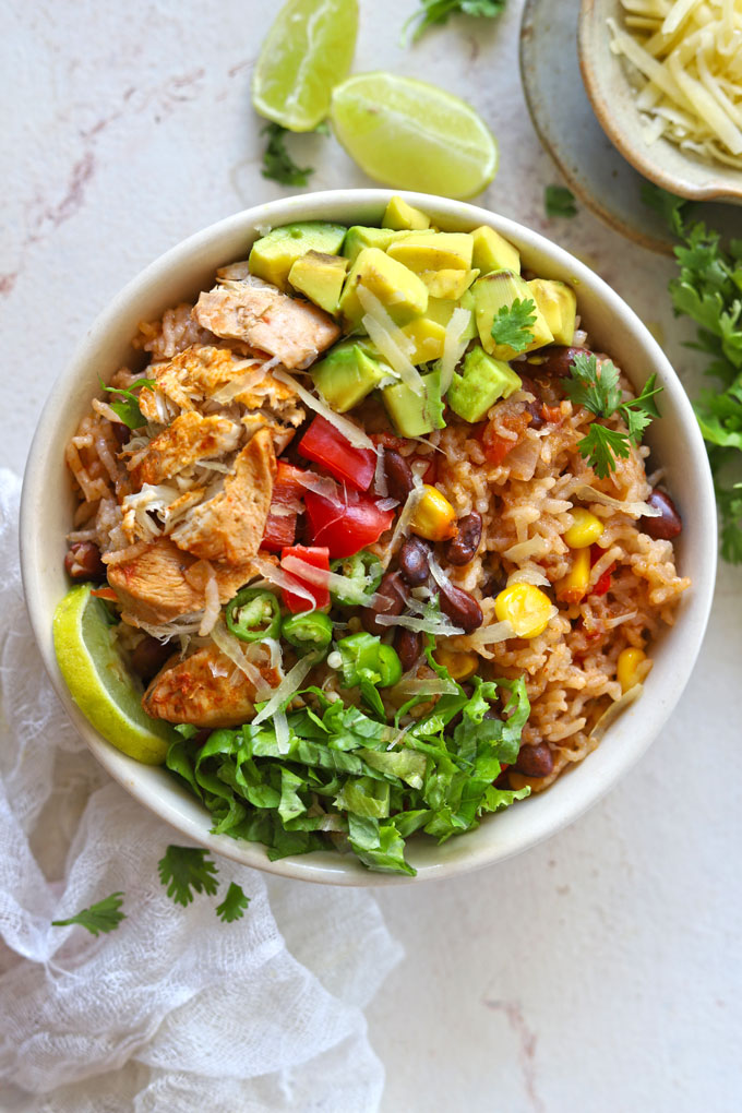 aerial shot of burrito bowl on white table with garnishes and cloth