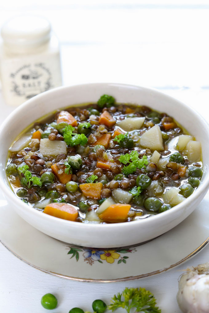 Lentil Stew in a white ceramic serving bowl on a white background.