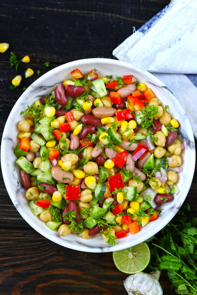 Aerial shot of Mexican style mixed beans salad in a white bowl.