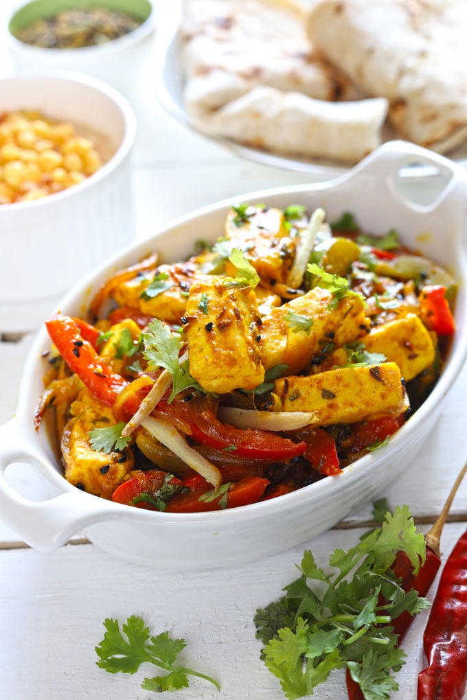 Side shot of vegetable jalfrezi in a white ceramic serving bowl. 