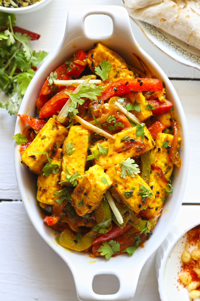 Aerial shot of paneer jalfrezi in an oval, white ceramic serving dish.