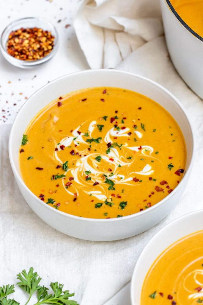 Red Lentil Carrot Soup in a white serving bowl.