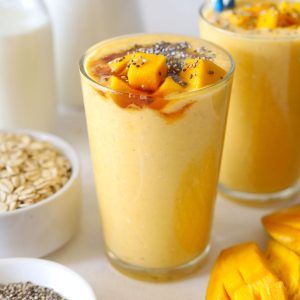 Side shot of mango oats breakfast smoothie in a glass.