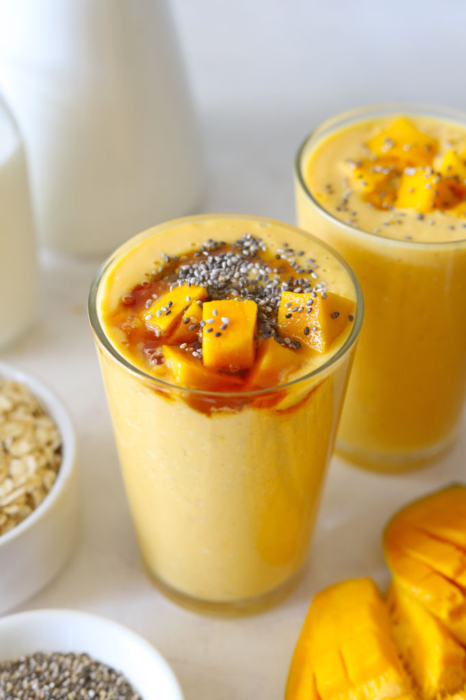 Side shot of mango oats breakfast smoothie in a glass.