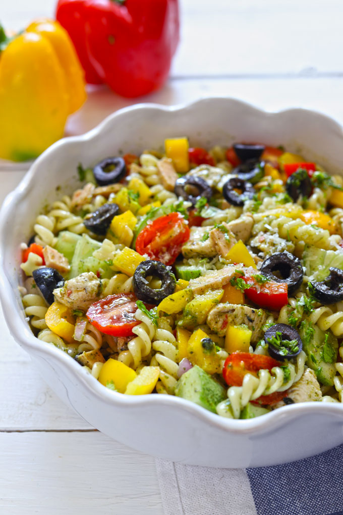 Side shot of chicken pasta salad in a white serving bowl.