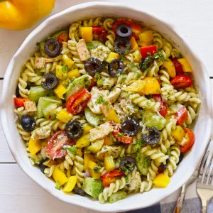 Aerial shot of chicken pasta salad in a white ceramic serving bowl.