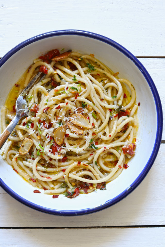 Aerial shot of spaghetti aglio e olio in a round enamel serving bowl