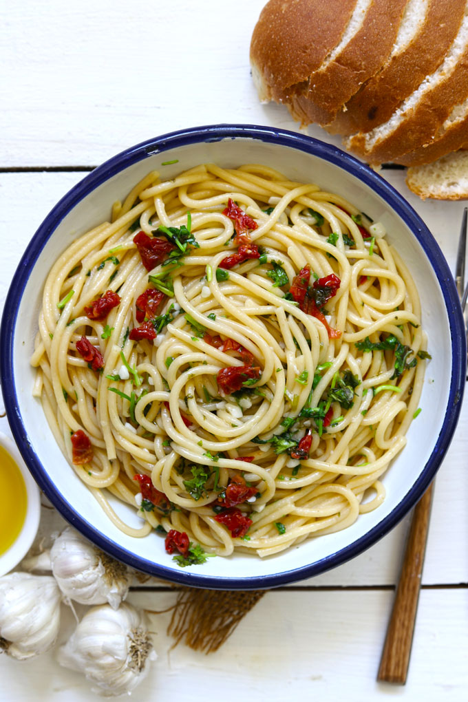 Aerial shot of spaghetti aglio e olio in a round enamel serving bowl.