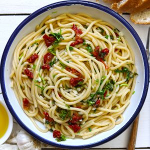 Aerial shot of spaghetti aglio e olio in a round enamel serving bowl
