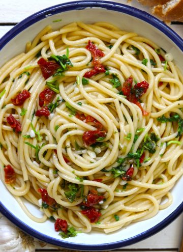 Aerial shot of spaghetti aglio e olio in a round enamel serving bowl