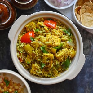 Aerial shot of paneer pulao in a ceramic cream color serving bowl.