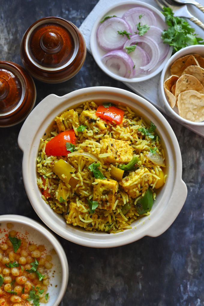 Aerial shot of achari paneer tikka pulao in a ceramic cream color serving bowl.