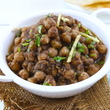 Side shot of chana masala in a white serving bowl