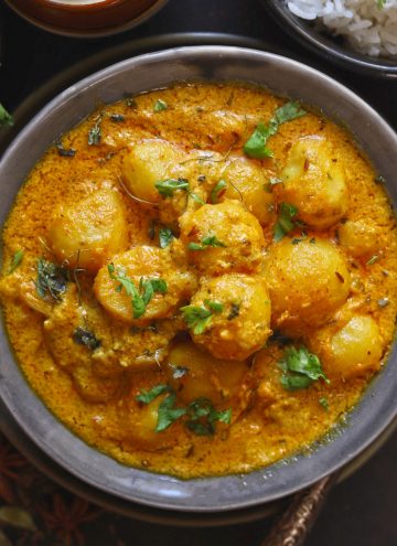 aerial shot of dum aloo in a grey ceramic serving bowl