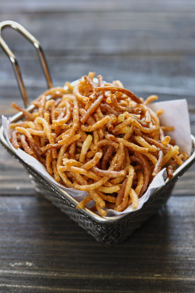 side shot of homemade crispy noodles in a wire basket