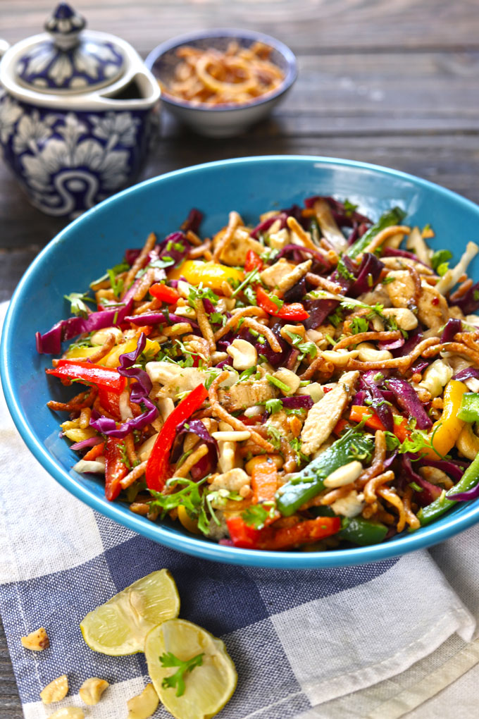 side shot of Chinese chicken salad in a blue ceramic bowl