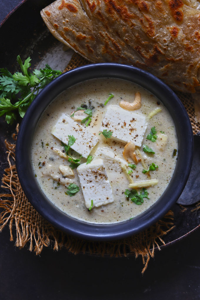 serial shot of paneer kali mirch in a black serving bowl