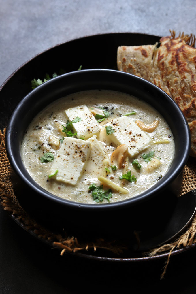 side shot of paneer kali mirch in a black serving bowl