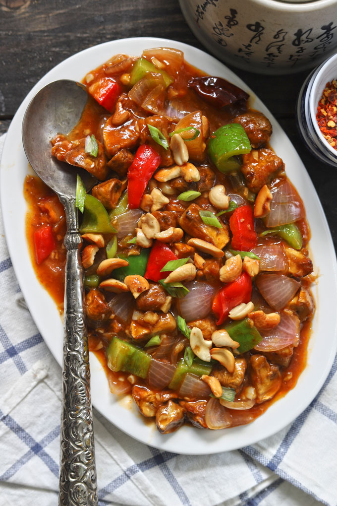 aerial shot of mushroom chilli in a white ceramic platter with a silver spoon