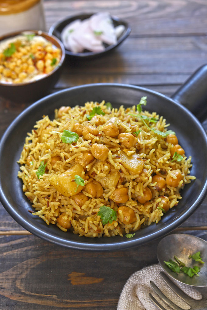 side shot of chana pulao in a black ceramic serving bowl