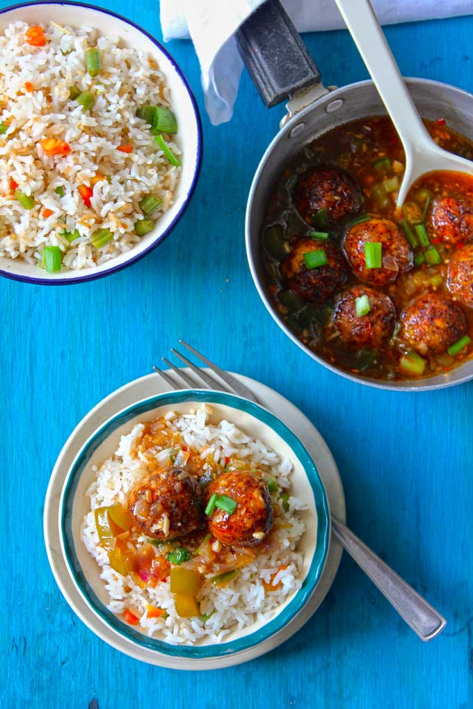 aerial shot of manchurian balls gravy over fried rice in a white bowl