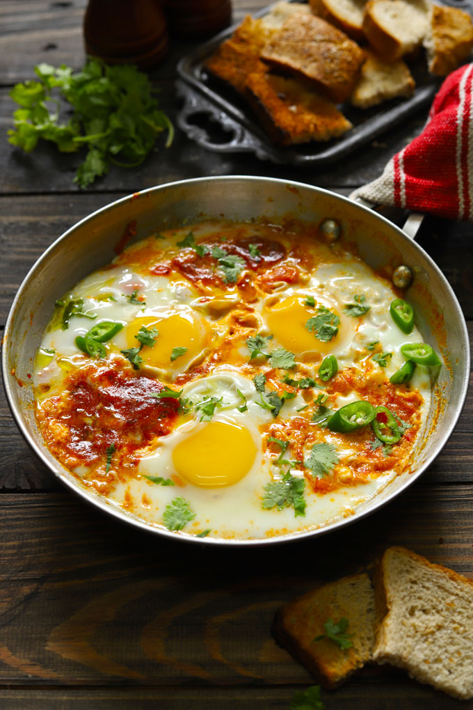 side shot of shakshuka in a stainless steel cooking pan