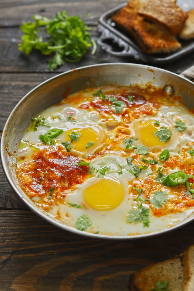 side shot of shakshuka in a stainless steel cooking pan